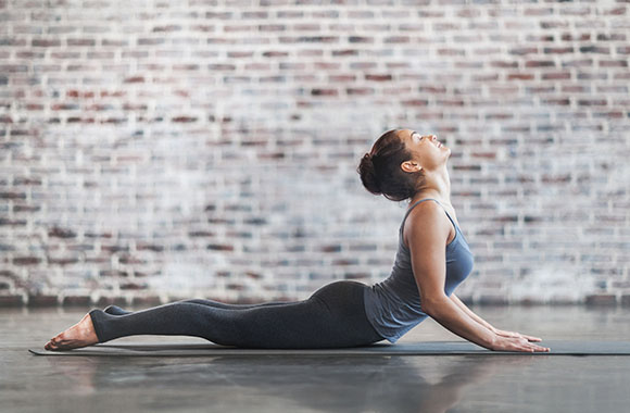 Anusara Yoga – woman in the yoga pose of the cobra. Anusara Yoga – woman in the yoga pose of the cobra.