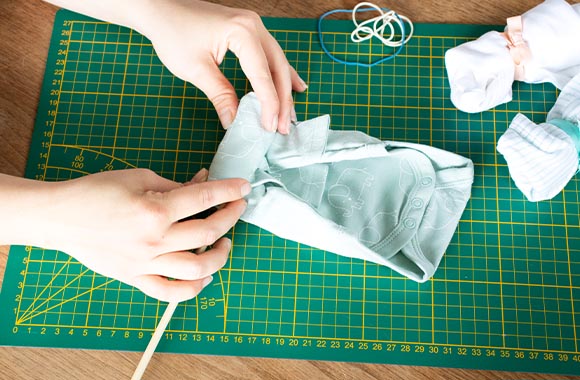 Rolling baby bodysuits to make a gift for first time parents.