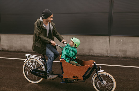 Tata przewozi syna na rowerze cargo. Tata przewozi syna na rowerze cargo.