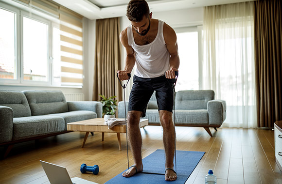 Man training at home using fitness tubes. Man training at home using fitness tubes.