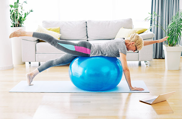 Woman training at home using a gym ball. Woman training at home using a gym ball.
