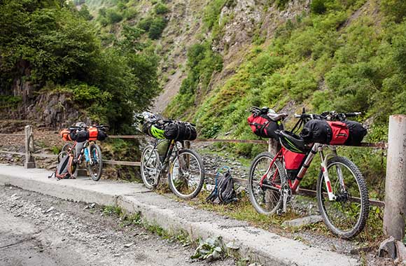 Fietsroute plannen - Drie fietsen geparkeerd en bepakt met zadel- en stuurtassen.