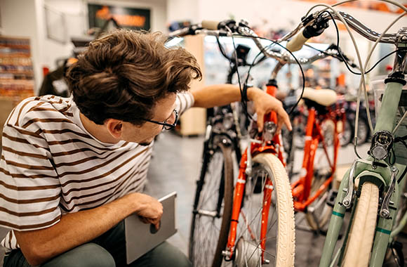 Cómo comprar una bicicleta: un chico examina al detalle una bicicleta. Cómo comprar una bicicleta: un chico examina al detalle una bicicleta.