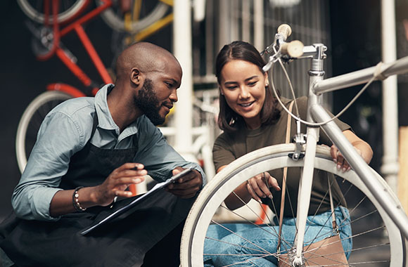Cómo comprar una bicicleta de segunda mano: una chica revisa una bicicleta de segunda mano junto con el vendedor. Cómo comprar una bicicleta de segunda mano: una chica revisa una bicicleta de segunda mano junto con el vendedor.