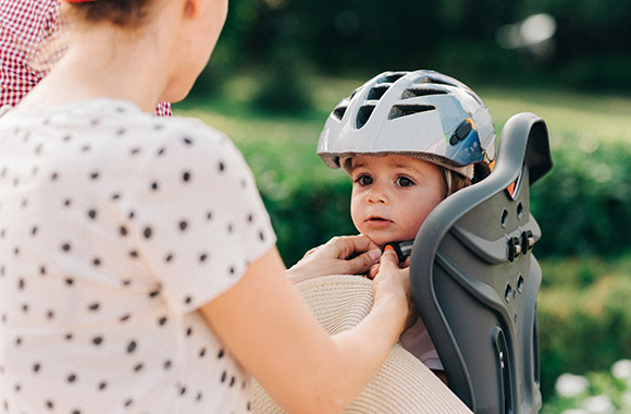 Baby mit Fahrrad mitnehmen: Kleiner Junge sitzt im Kinderfahrradsitz. Baby mit Fahrrad mitnehmen: Kleiner Junge sitzt im Kinderfahrradsitz.