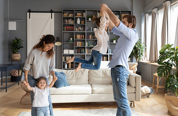 Bewegungsspiele: Familie tanz ausgelassen im Wohnzimmer. Bewegungsspiele: Familie tanzt ausgelassen im Wohnzimmer.