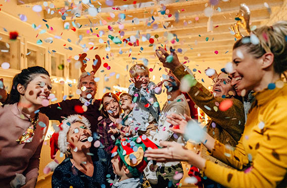 New Year’s Eve games for children: A family celebrates New Year’s Eve together by throwing confetti.