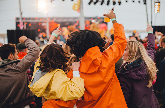 A festival in the rain: festivalgoers in high spirit and wearing raincoats. A festival in the rain: festivalgoers in high spirit and wearing raincoats.