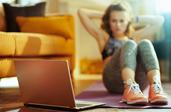 Online fitness: young woman training with instruction from a video workout. Online fitness: young woman training with instruction from a video workout.