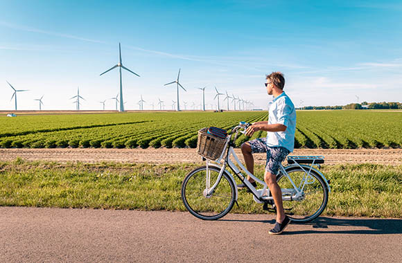 Fietsroutes Flevoland - man met elektrische groene fiets in Flevoland Nooroostpolder. Fietsroutes Flevoland - man met elektrische groene fiets in Flevoland Nooroostpolder.