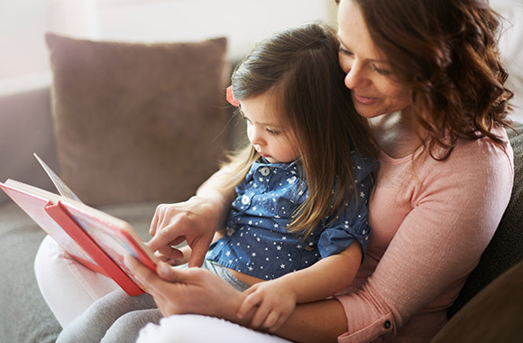 Mutter und Tochter entdecken gemeinsam kindgerechte Geschichten zum Vorlesen.