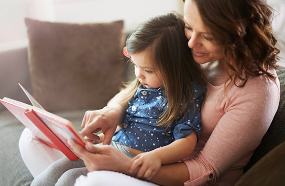 Mutter und Tochter entdecken gemeinsam kindgerechte Geschichten zum Vorlesen. Mutter und Tochter entdecken gemeinsam kindgerechte Geschichten zum Vorlesen.