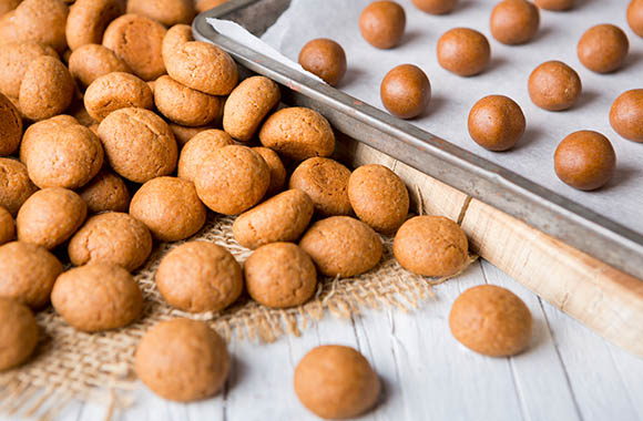 Pepernoten bakken – kruidnoten op de bakplaat en al gebakken pepernoten. Pepernoten bakken – kruidnoten op de bakplaat en al gebakken pepernoten.