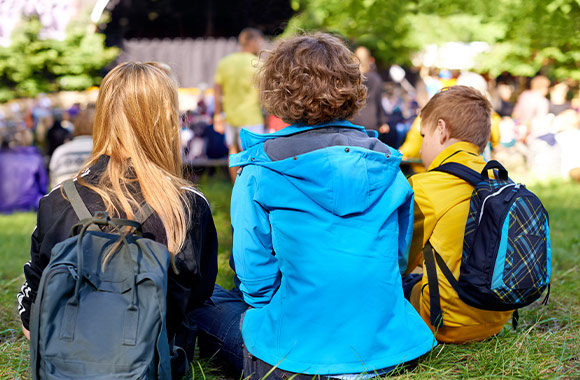Festival tips for parents: a group of children sitting at the edge of the event area. Festival tips for parents: a group of children sitting at the edge of the event area.
