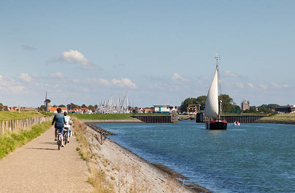 Mensen fietsen langs de haven in Zierikzee. Mensen fietsen langs de haven in Zierikzee.