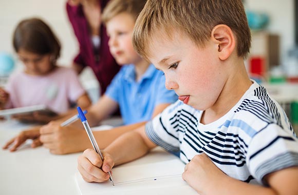 Junge lernt Schreiben im Klassenzimmer. Junge lernt Schreiben im Klassenzimmer.