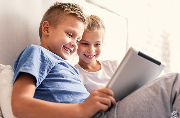 Kinderen leren lezen met behulp van een lees app op hun tablet.