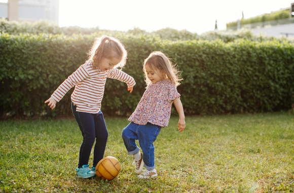 Kindvriendelijke tuin: broers en zussen spelen samen met een bal.