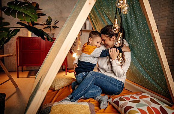 Beschäftigung Kleinkinder - Mutter und Sohne genießen den Nachmittag in einer selbstgebauten Höhle.