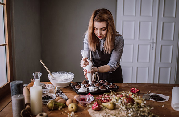 Baking for beginners: Woman bakes cupcakes.