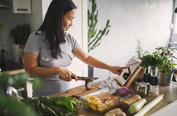 Cooking for beginners: Woman reading a recipe on her tablet.