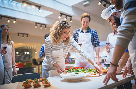 Trouver un hobby : des participants à un cours de cuisine présentent leurs plats.
