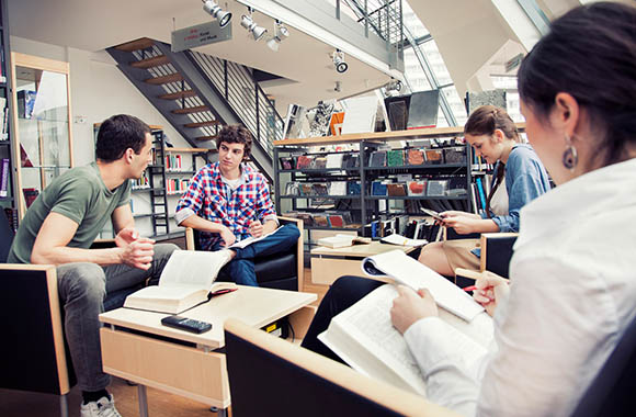 Studenten studeren samen in de bibliotheek.