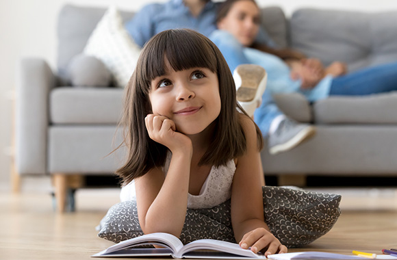 Leseverständnis fördern: Kleines Mädchen denkt über das Gelesene nach.