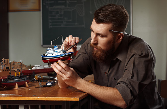 Model making: A man working on his model ship.