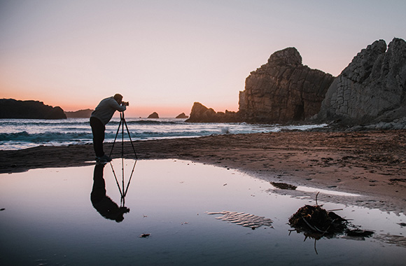 Photographing nature: A man taking a photo on the beach.