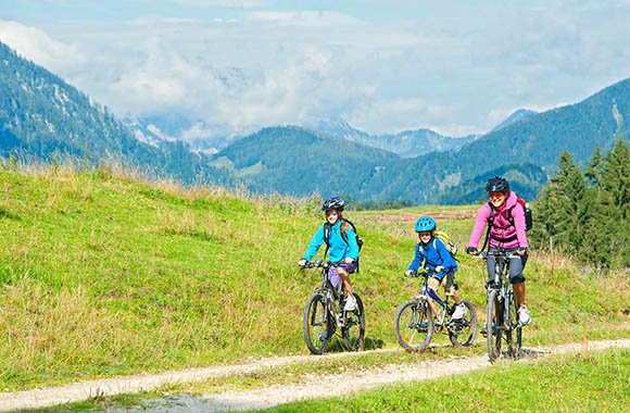 Fietsroute kinderen: moeder maakt een fietstochtje met haar kinderen.