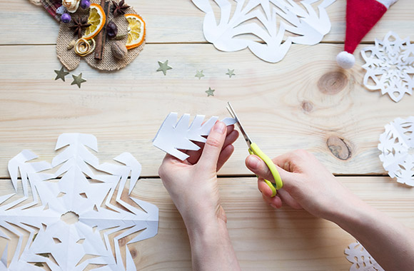 Fiocchi di neve fai da te: bambino crea fiocchi di neve con la carta. Fiocchi di neve fai da te: bambino crea fiocchi di neve con la carta.