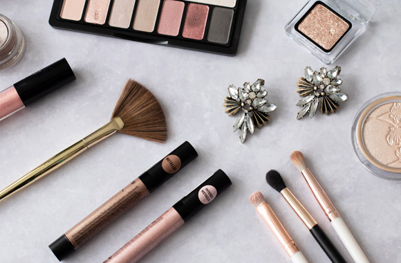 Eye shadow, highlighter, and make-up brushes on a dressing table.