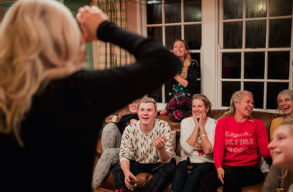 Juego de mímica para Nochevieja: una mujer hace mímica delante de su grupo de amigos.