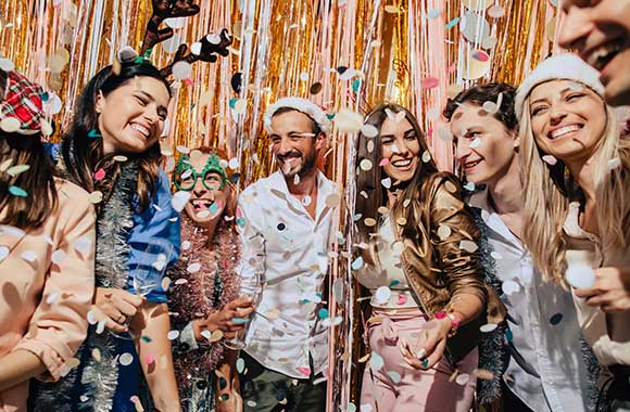 Party games New Year’s Eve: group dresses up and throws confetti.