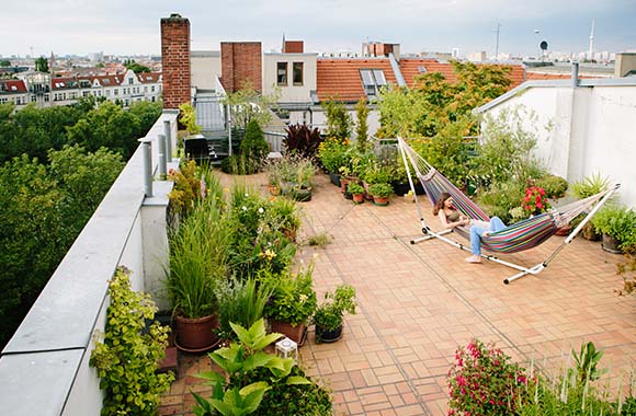 Urban gardening – twee vrouwen liggen in de hangmat op het dakterras.