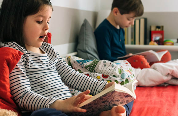 Motivare alla lettura: fratello e sorella passano del tempo a leggere insieme.