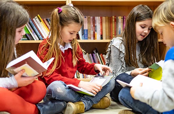 Kinder lesen Bücher in der Bibliothek.