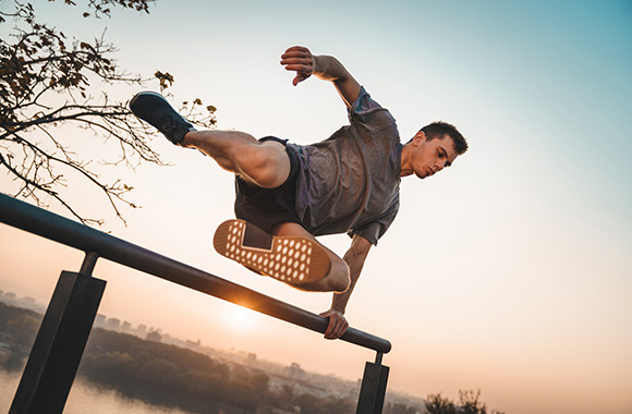 Parcour – man jumping over a railing. Parcour – man jumping over a railing.