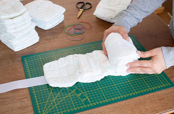 Rolling the body of the homemade nappy cake.