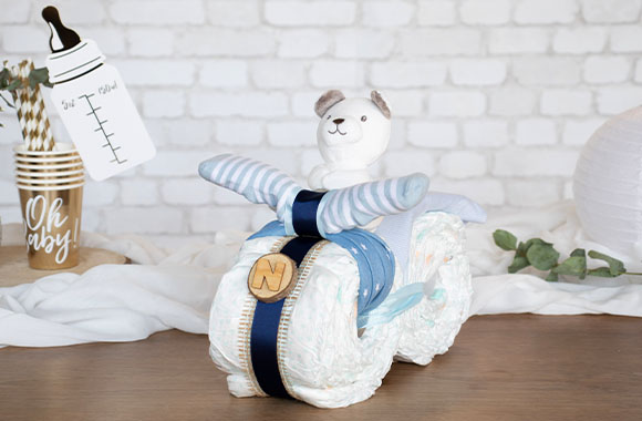 A finished motorbike nappy cake in shades of blue.
