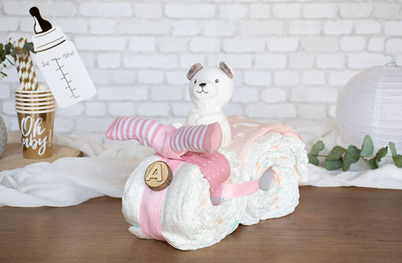 A finished girls’ motorcycle diaper cake in pink.