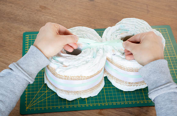 Make a motorbike nappy cake - connect diaper wheels with ribbon.