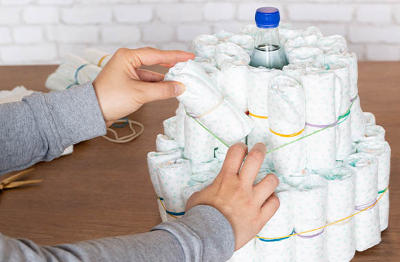 Stack the rolled-up nappies for the diaper cake. Stack the rolled-up nappies for the diaper cake.