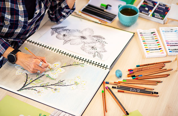 Close-up of a woman drawing flowers.