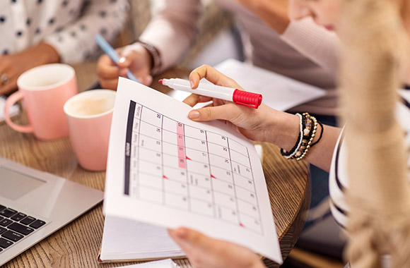 Optymalizacja czasu pracy na studiach: studentka tworzy plan dnia w kalendarzu. 