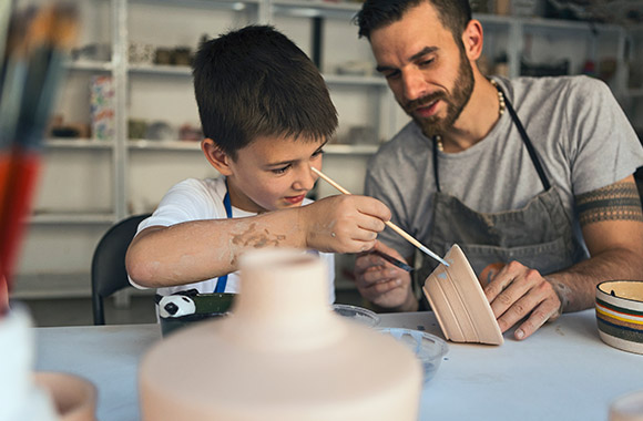Gezinsuitstapje: vader en zoon volgen een workshop pottenbakken. Gezinsuitstapje: vader en zoon volgen een workshop pottenbakken.