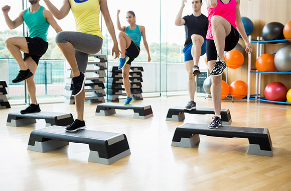 Dance workout: cursisten trainen met step-aerobics in de sportzaal. Dance workout: cursisten trainen met step-aerobics in de sportzaal.