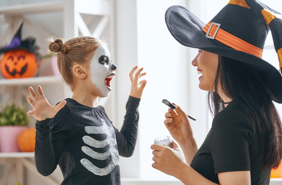 Make your own face paint: a little girl having her face painted with a Halloween design by her mum. Make your own face paint: a little girl having her face painted with a Halloween design by her mum.