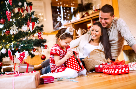 Christmas presents for children - a family unwrapping their Christmas presents together.